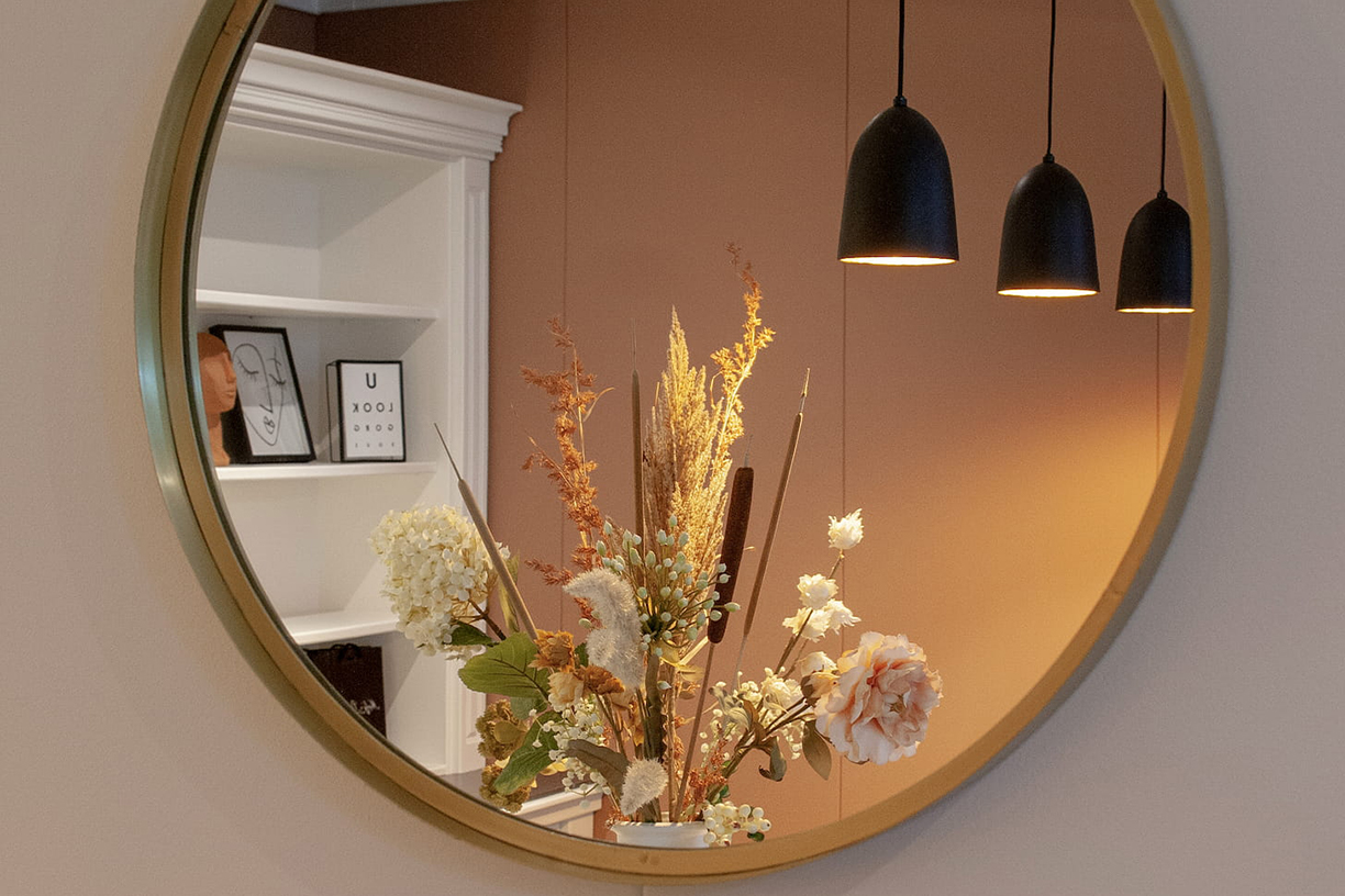 Gouden ronde spiegel met droogbloemen en sfeerverlichting